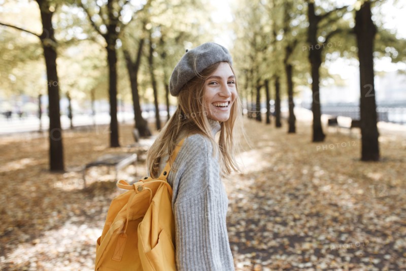 Young woman with yellow backpack in park in Berlin, Germany