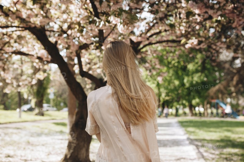 Blond haired woman by blossoming trees