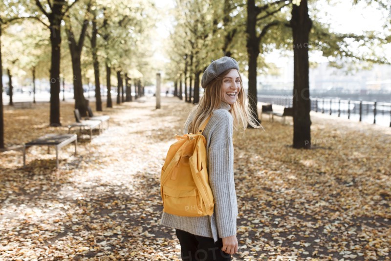 Young woman with yellow backpack in park in Berlin, Germany