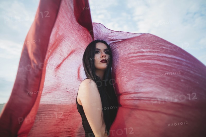Young woman with windswept red scarf