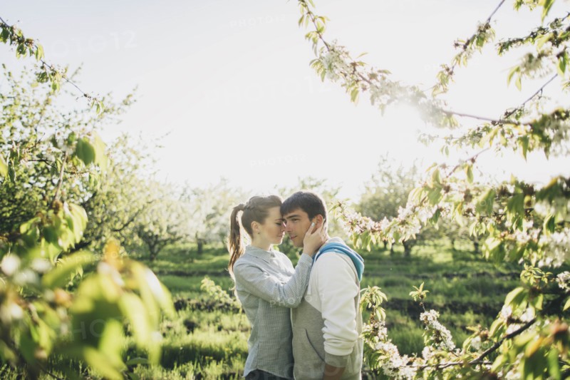 Young couple embracing by trees