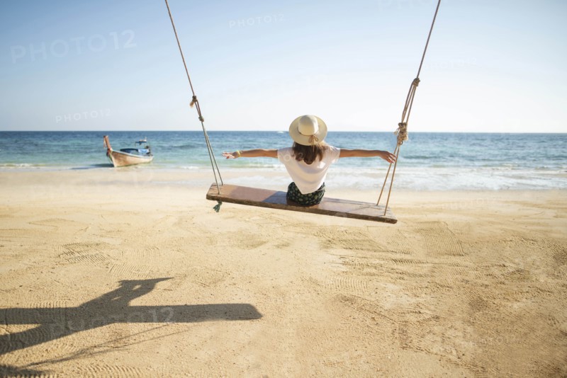 Young woman on swing at beach