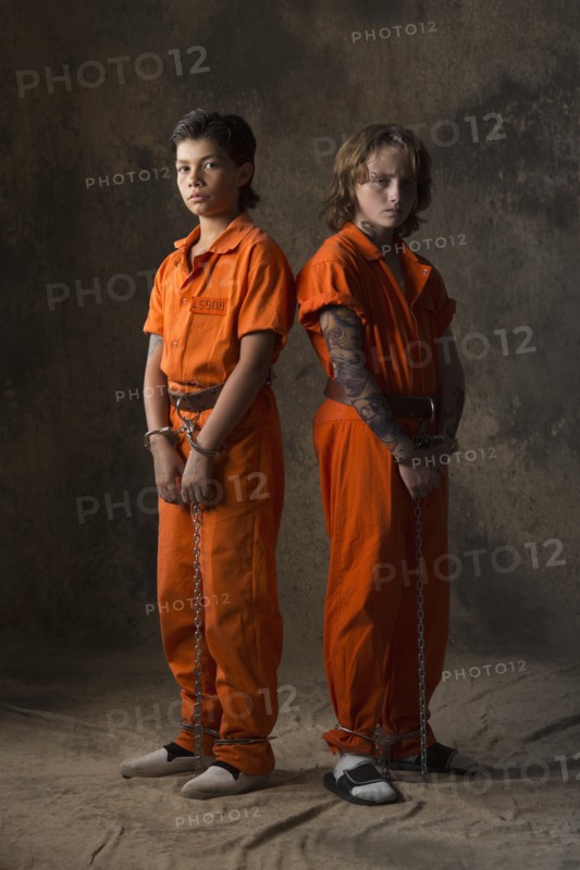 Boys in prisoner jumpsuits and handcuffs