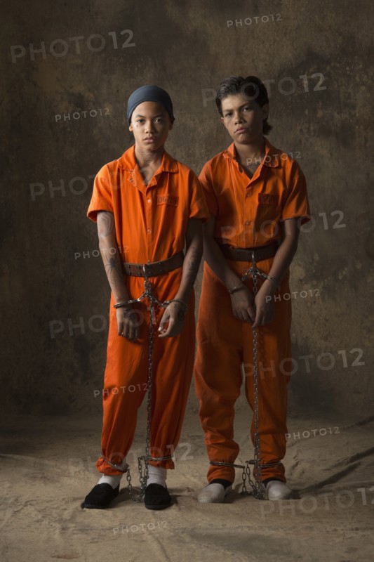 Boys in prisoner jumpsuits and handcuffs
