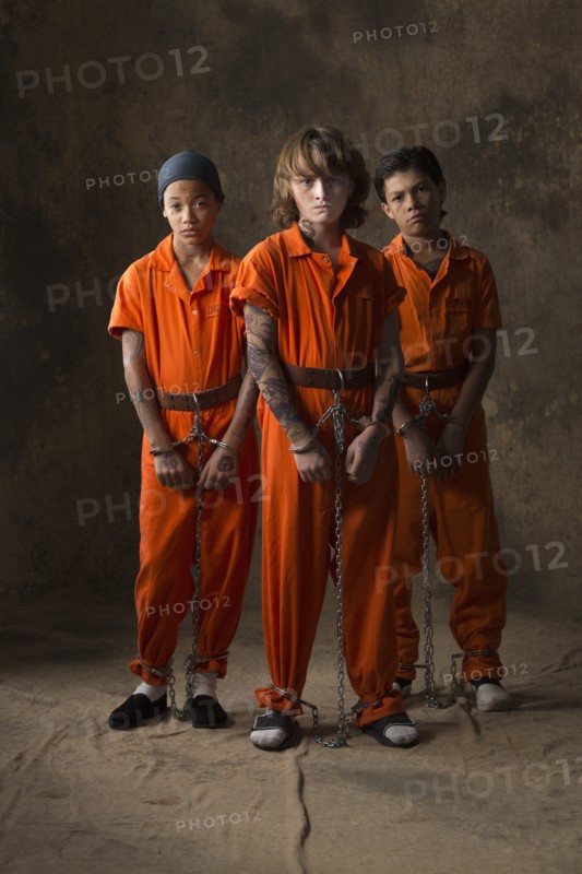 Boys in prisoner jumpsuits and handcuffs