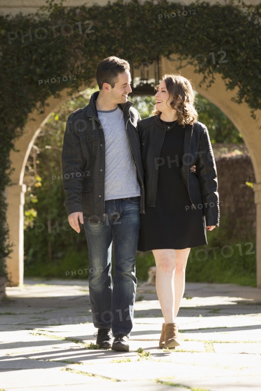 Young couple walking by arch