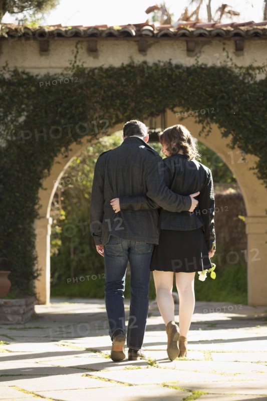 Rear view of young couple walking by arch
