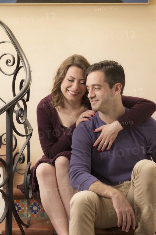 Smiling young couple sitting on staircase