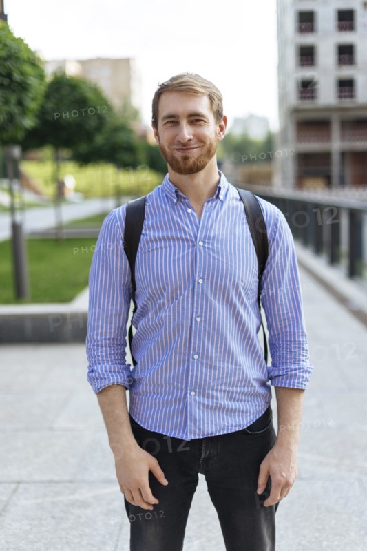 Man wearing striped shirt and backpack in city