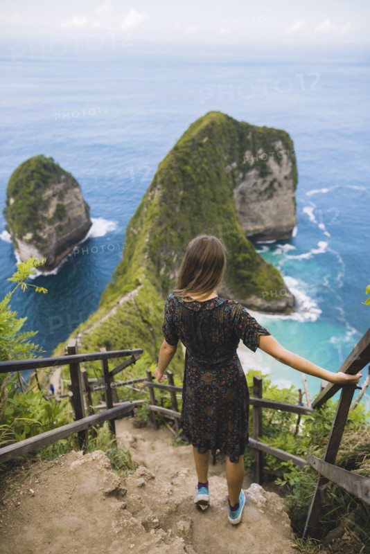 Woman on hillside steps above Kelingking Beach in Nusa Penida, Indonesia