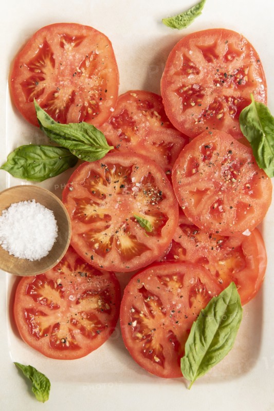 Sliced tomatoes with basil and salt