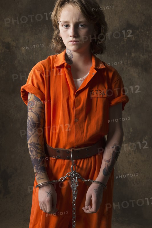 Boy in prisoner jumpsuit and handcuffs