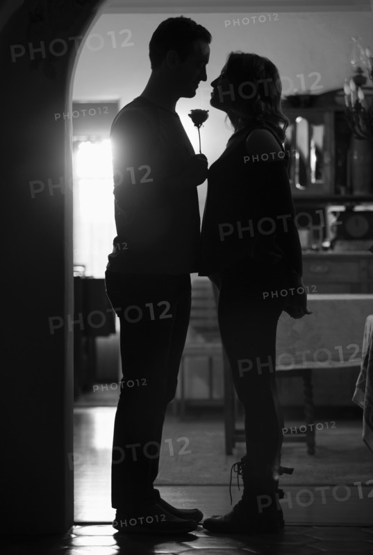 Silhouettes of couple with rose in doorway
