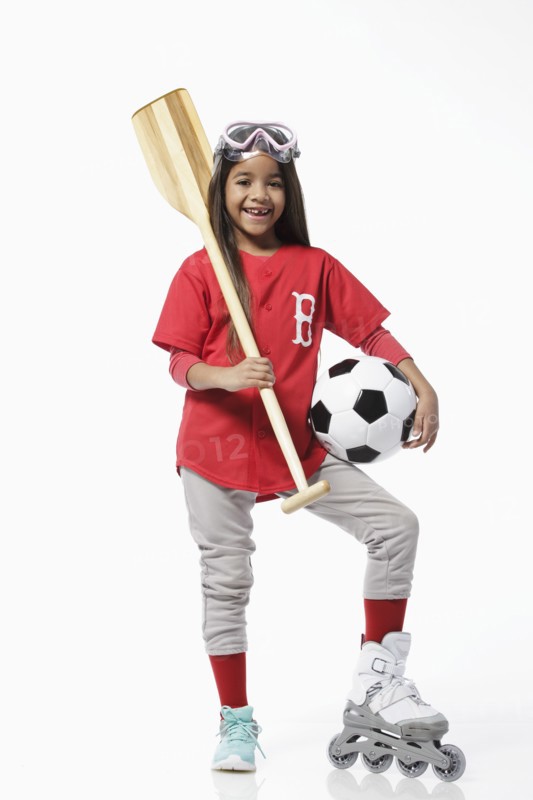 Girl dressed in baseball uniform holding sports equipment