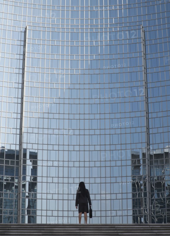 Businesswoman by reflective office building