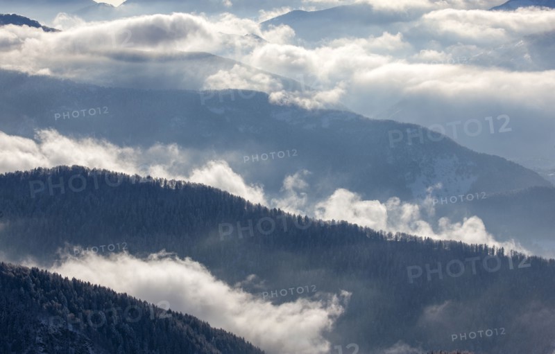 Fog over forest covered mountains in Piedmont, Italy