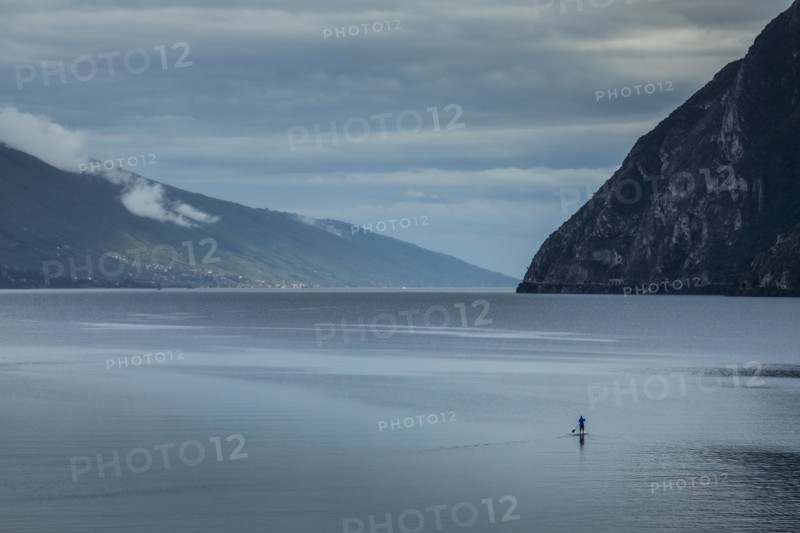 Man paddleboarding on Lake Garda, Italy