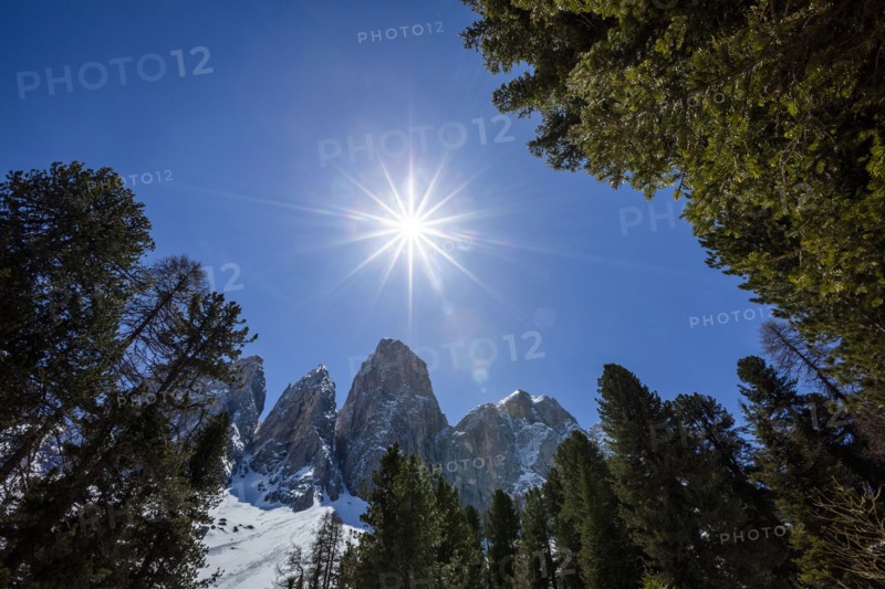 Sun over mountain range in Dolomites, Italy