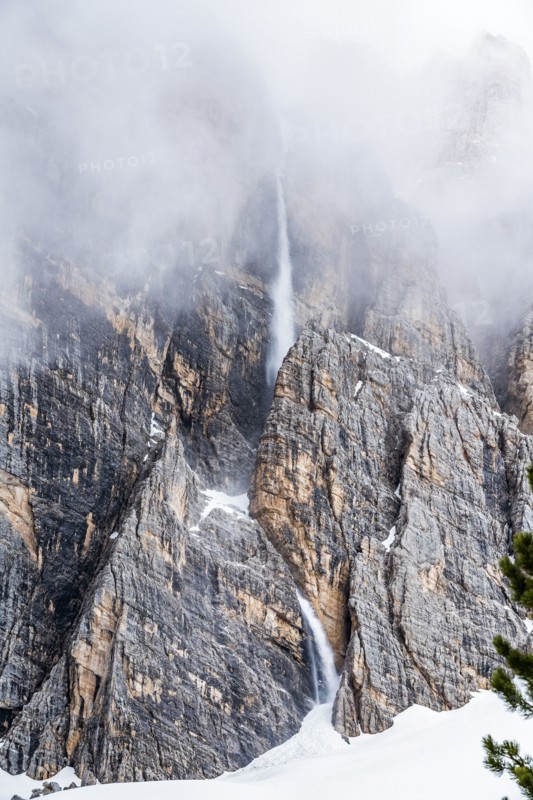 Snow falling down cliff in Dolomites, Italy