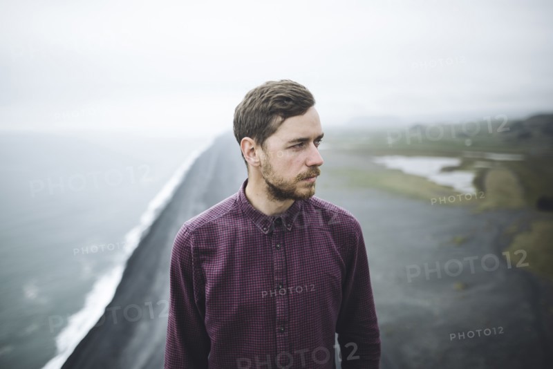 Bearded man above beach in Vik, Iceland