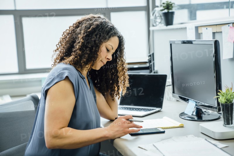 Woman using smart phone in office