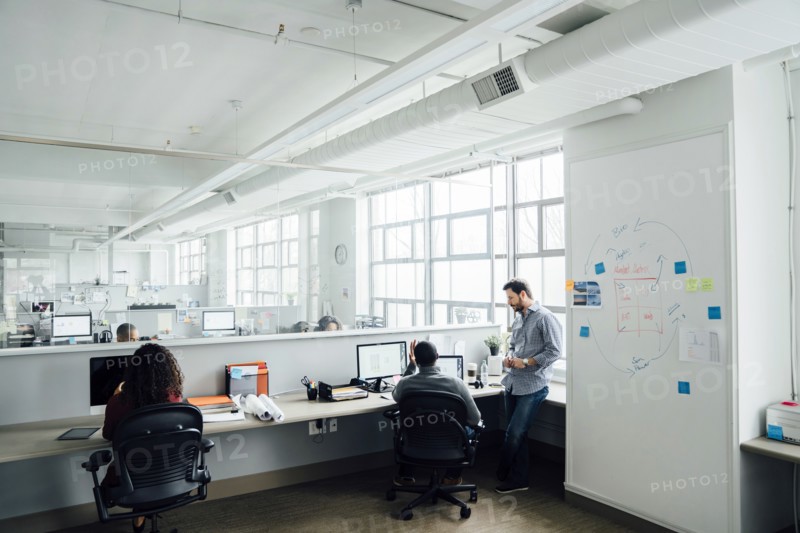 Workers using computers in office