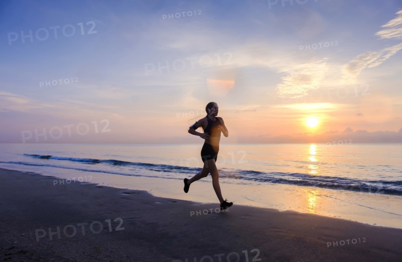 Woman jogging on beach at sunset