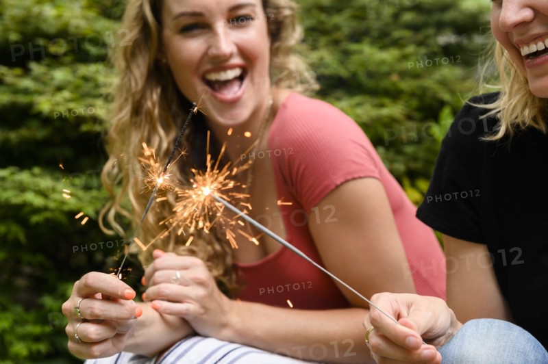 Smiling women holding sparkler