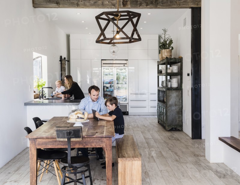 Father and son using digital tablet at dining table