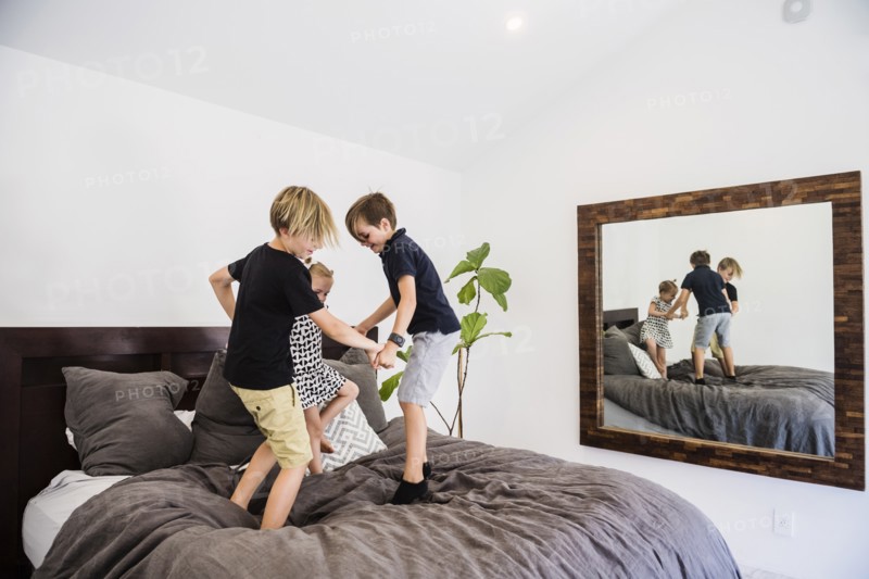 Children jumping on bed