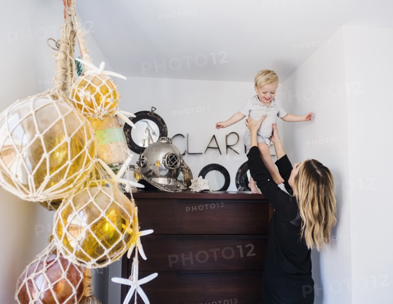 Mother holding son on top of drawers