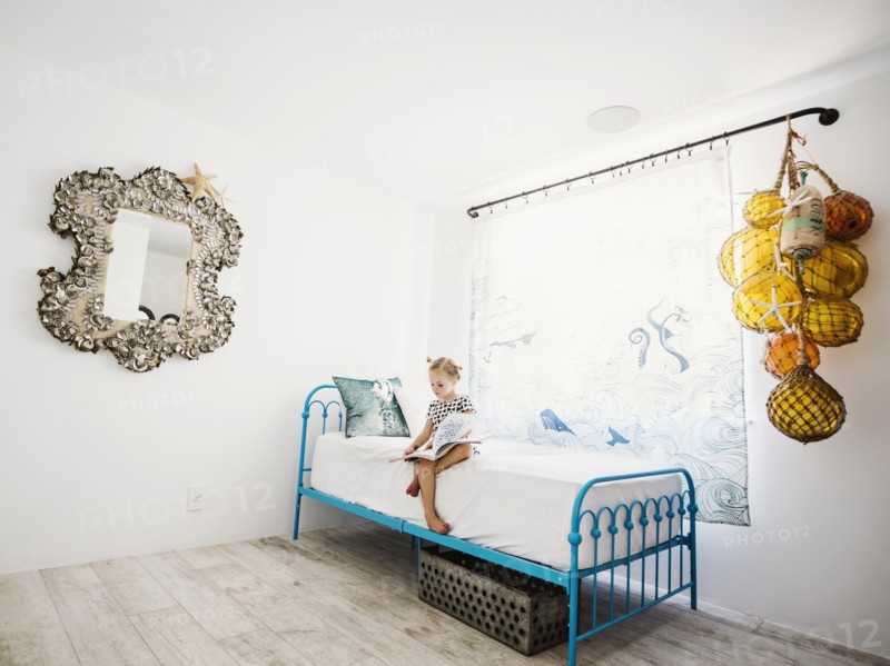 Girl reading book on bed