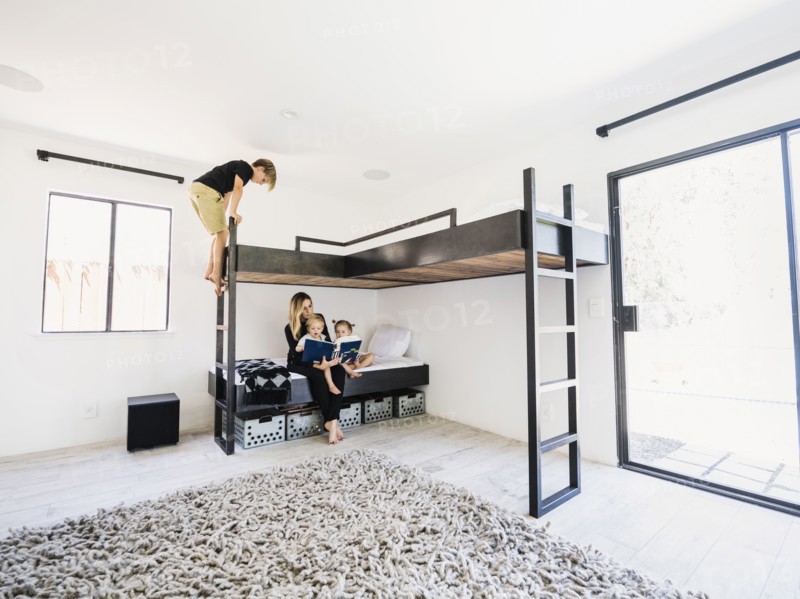 Mother reading story to children on bunk bed