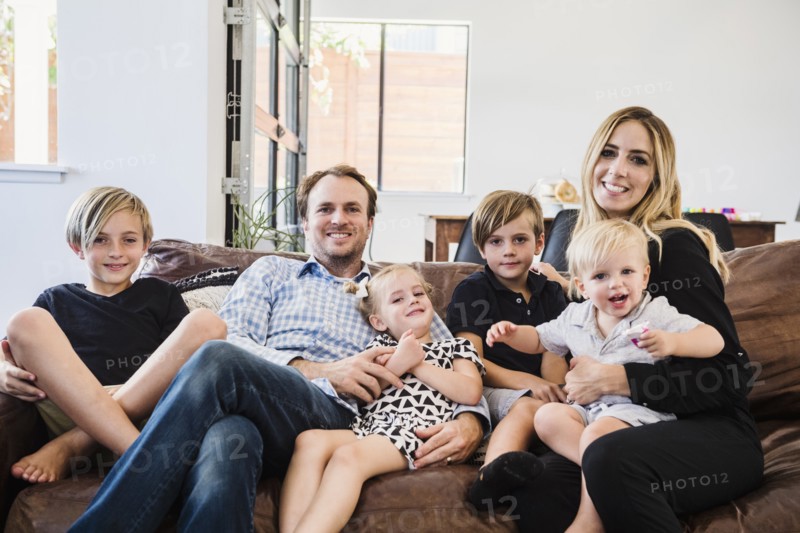 Smiling family sitting on leather sofa
