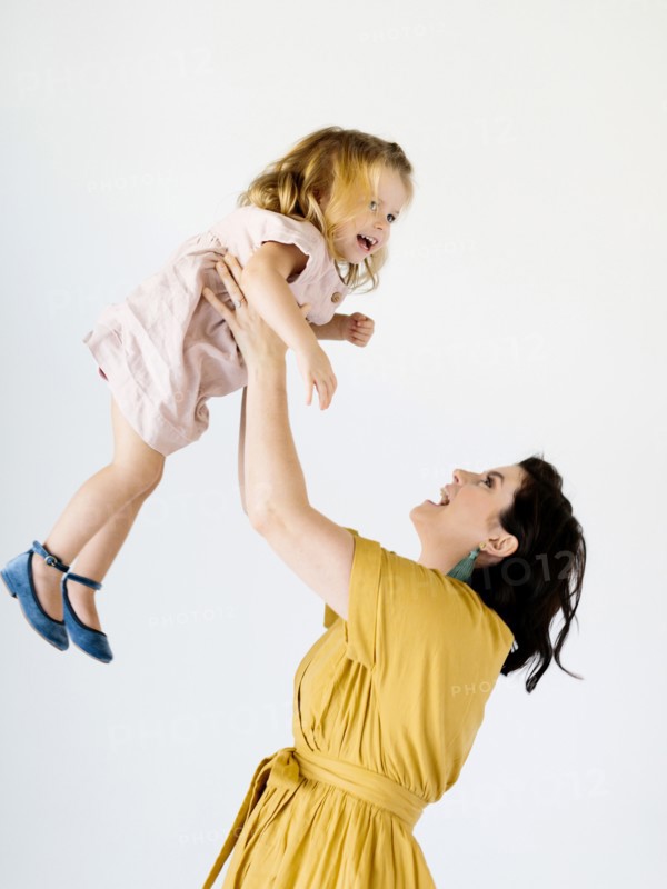Mother holding her daughter aloft