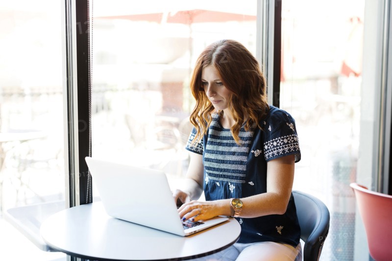 Woman using laptop in cafe