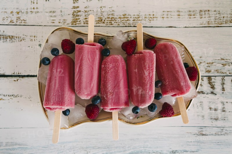 Berry ice pops with berries on plate