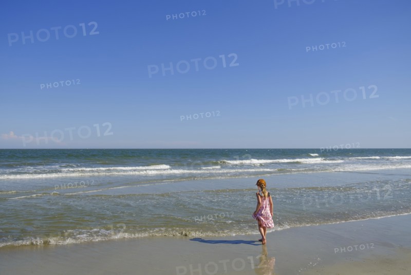 Rear view of girl walking on beach