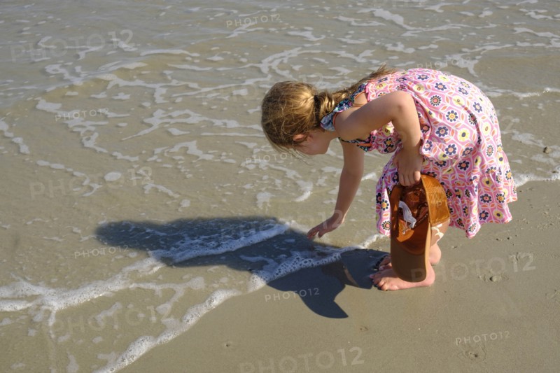 Girl bending over on beach