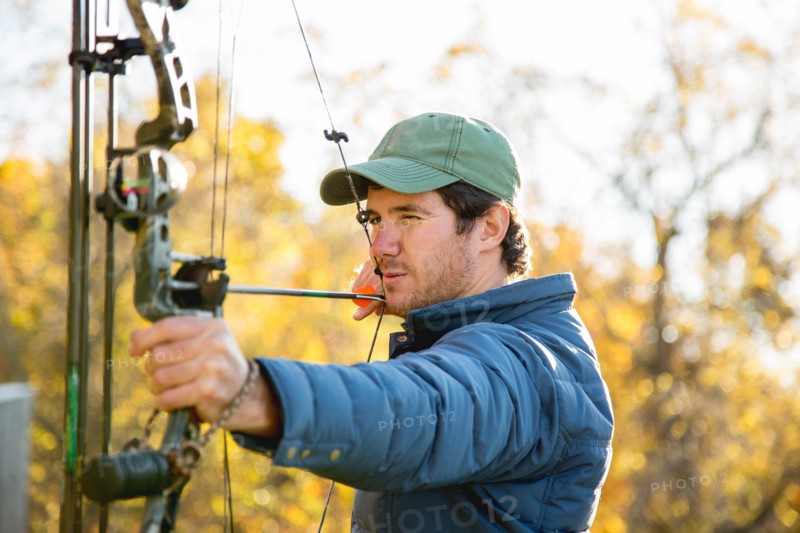 Young man aiming bow and arrow