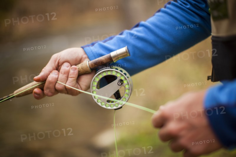 Man's hands holding fishing rod