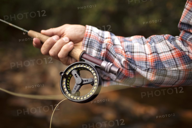 Hand of man holding fishing rod