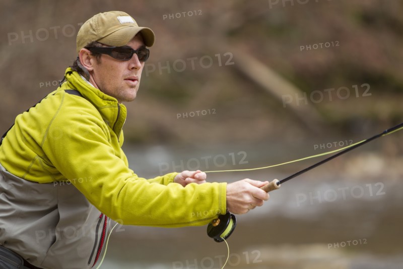 Young man fly-fishing in river