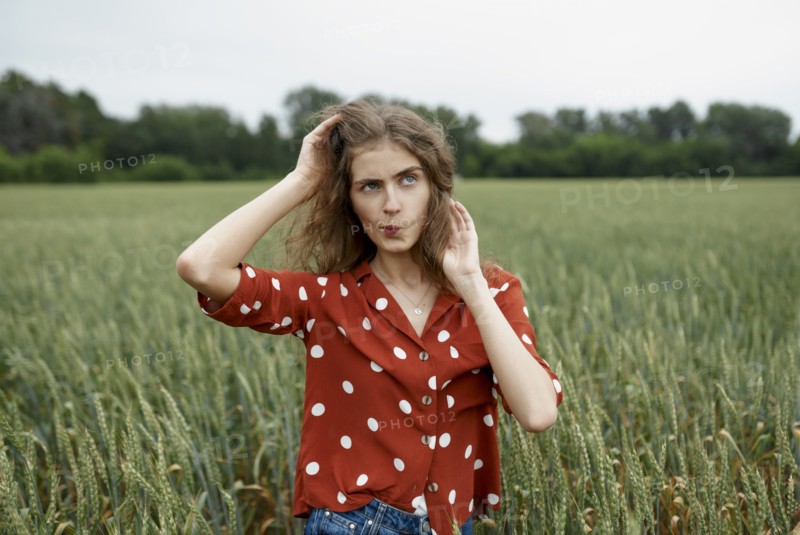 Woman making face in wheat field