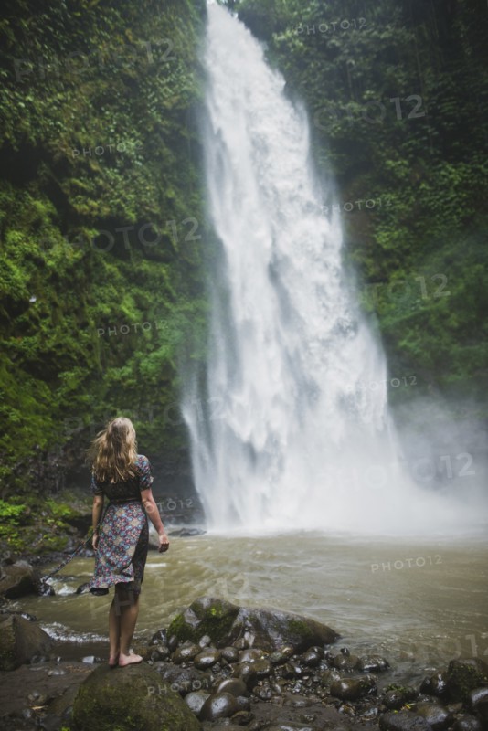 Woman standing by waterfall in Bali