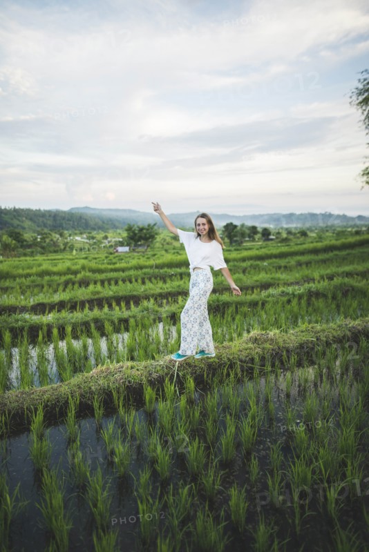 Woman walking in rice paddy in Bali
