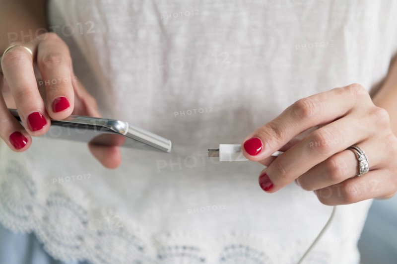 Woman plugging charger into smart phone