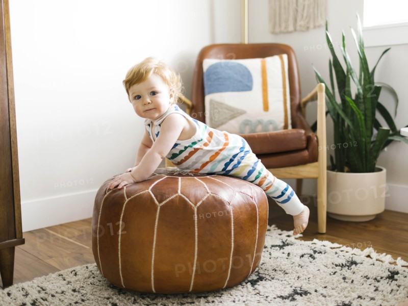 Baby boy lying on ottoman