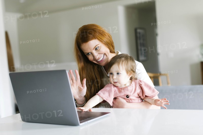 Mother and daughter using laptop to video chat