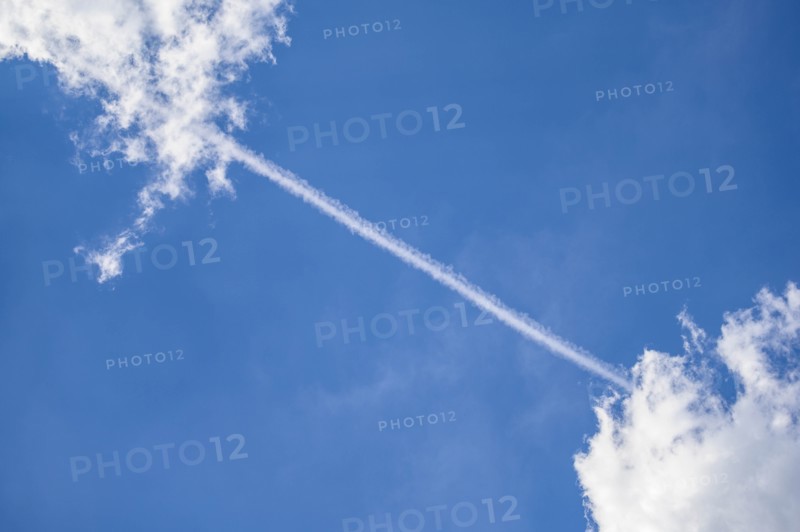 Vapor trail between clouds